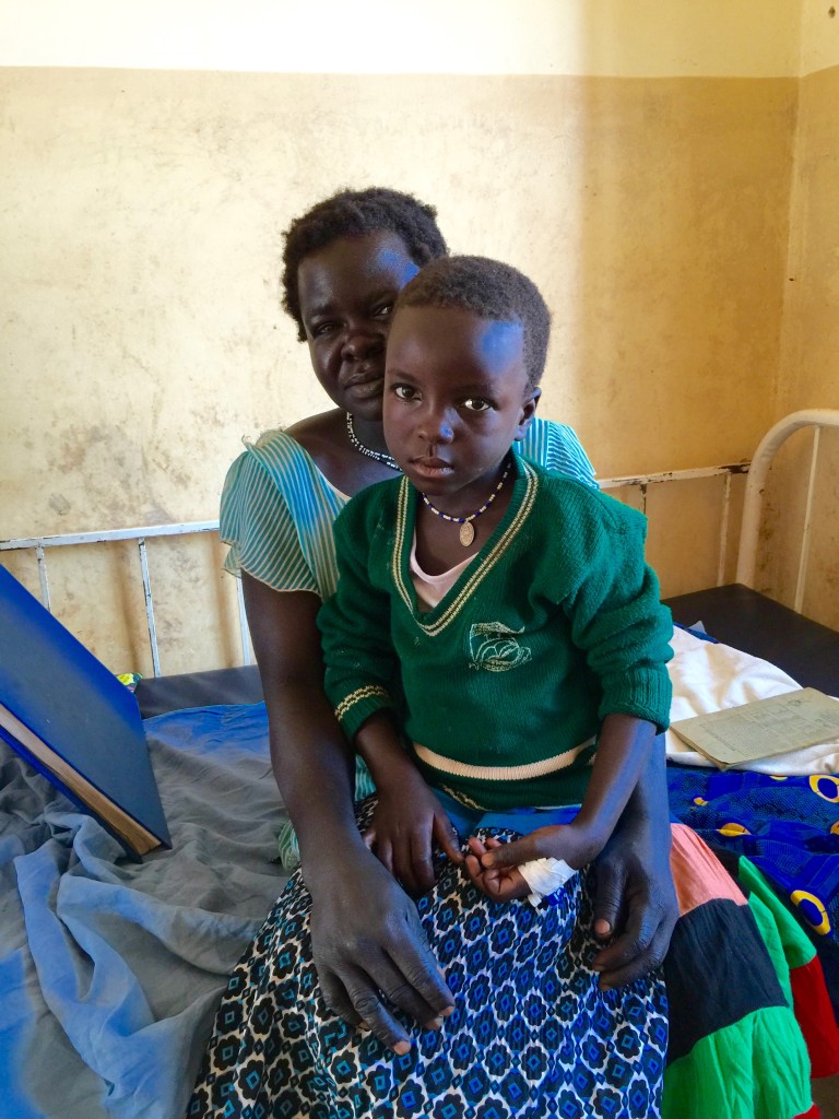 Mother and child with the IV connection in back of hand. 